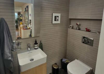 Salle de bain avec meuble vasque et WC suspendu par Pred SA à Fribourg