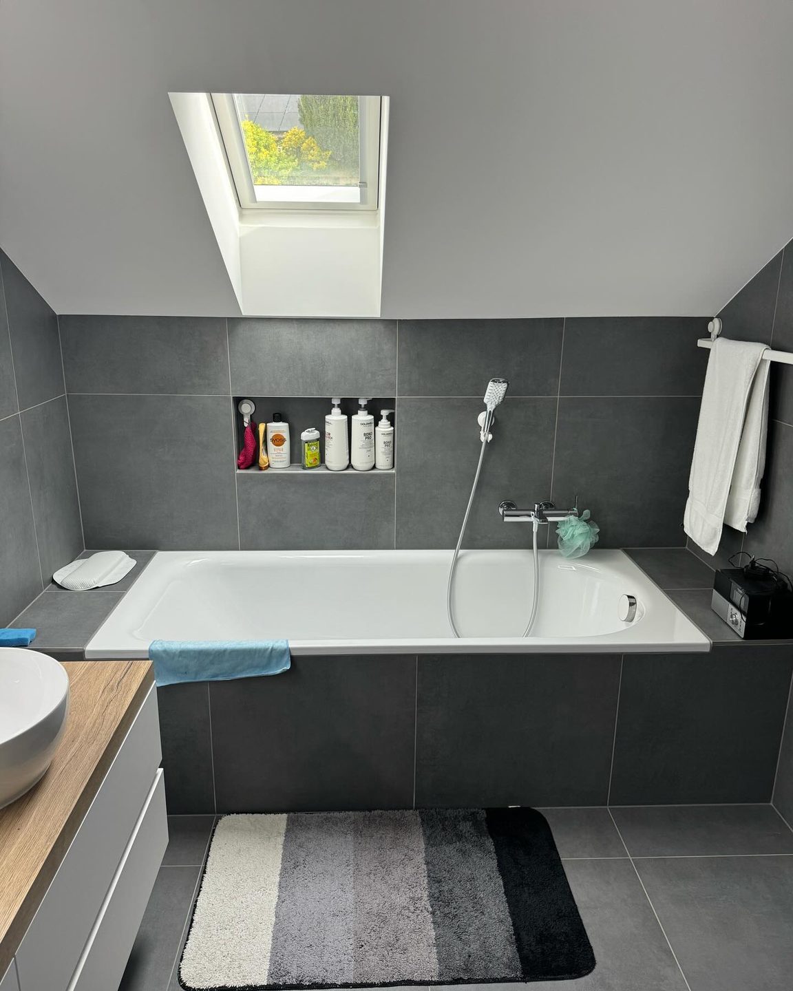 Salle de bain sous les combles agrandie par Pred SA, baignoire sous la fenêtre de toit