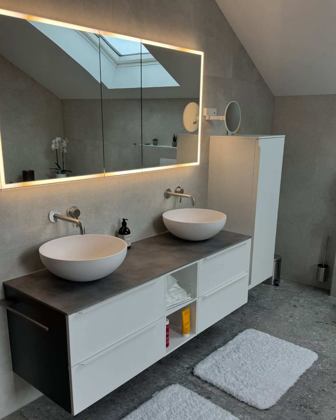 Salle de bain rénovée par Pred SA dans une villa à Cottens, double vasque et miroir lumineux