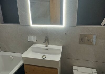 Meuble vasque, baignoire et WC douche dans une salle de bain en PPE rénovée par Pred SA